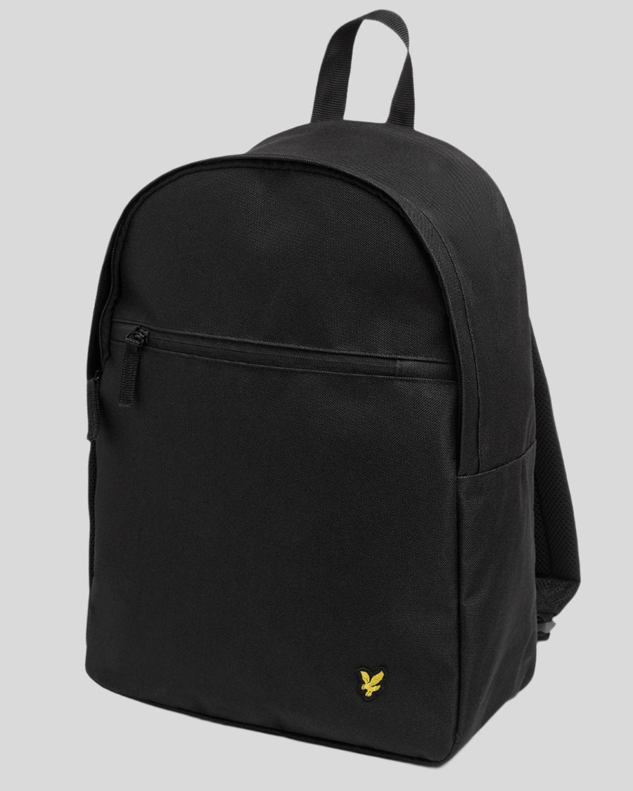 Un garçon porte un sac à dos noir de jais