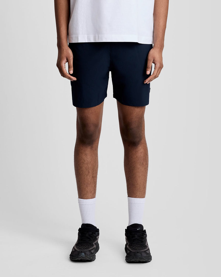 Un homme porte un short de bain bleu marine foncé