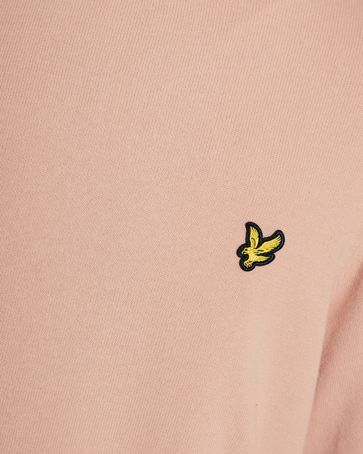 Homme portant un pull à col rond en coton couleur pamplemousse rose