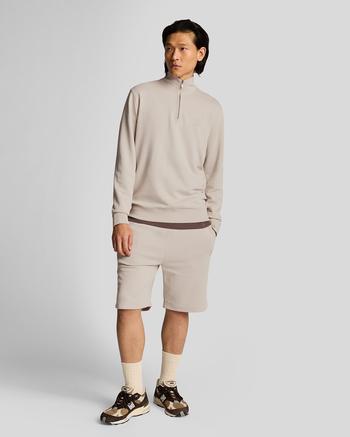 Un homme porte un sweat-shirt à fermeture éclair 1/4 en coton ultra-fin, couleur Cove
