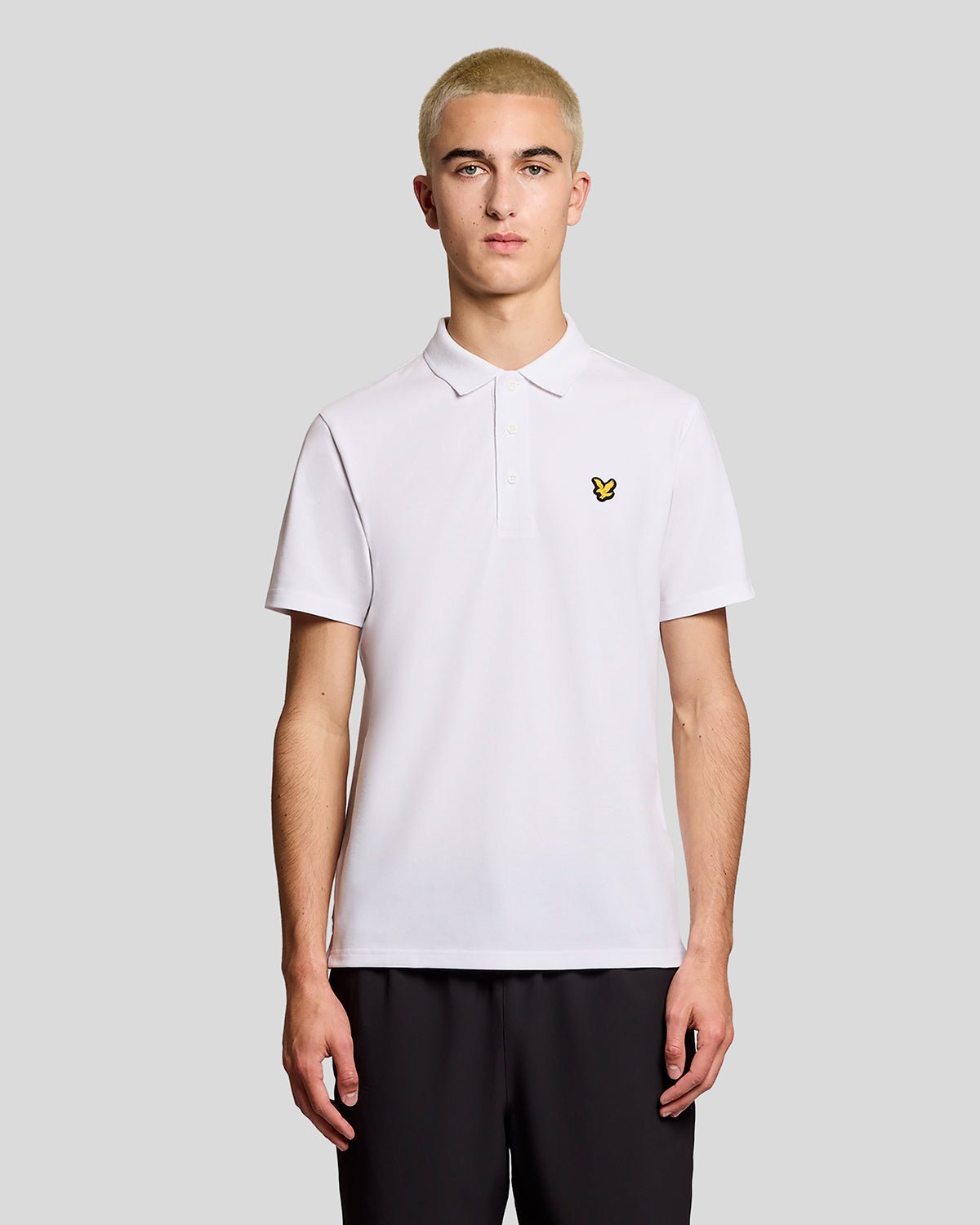 Un homme porte un polo de sport blanc