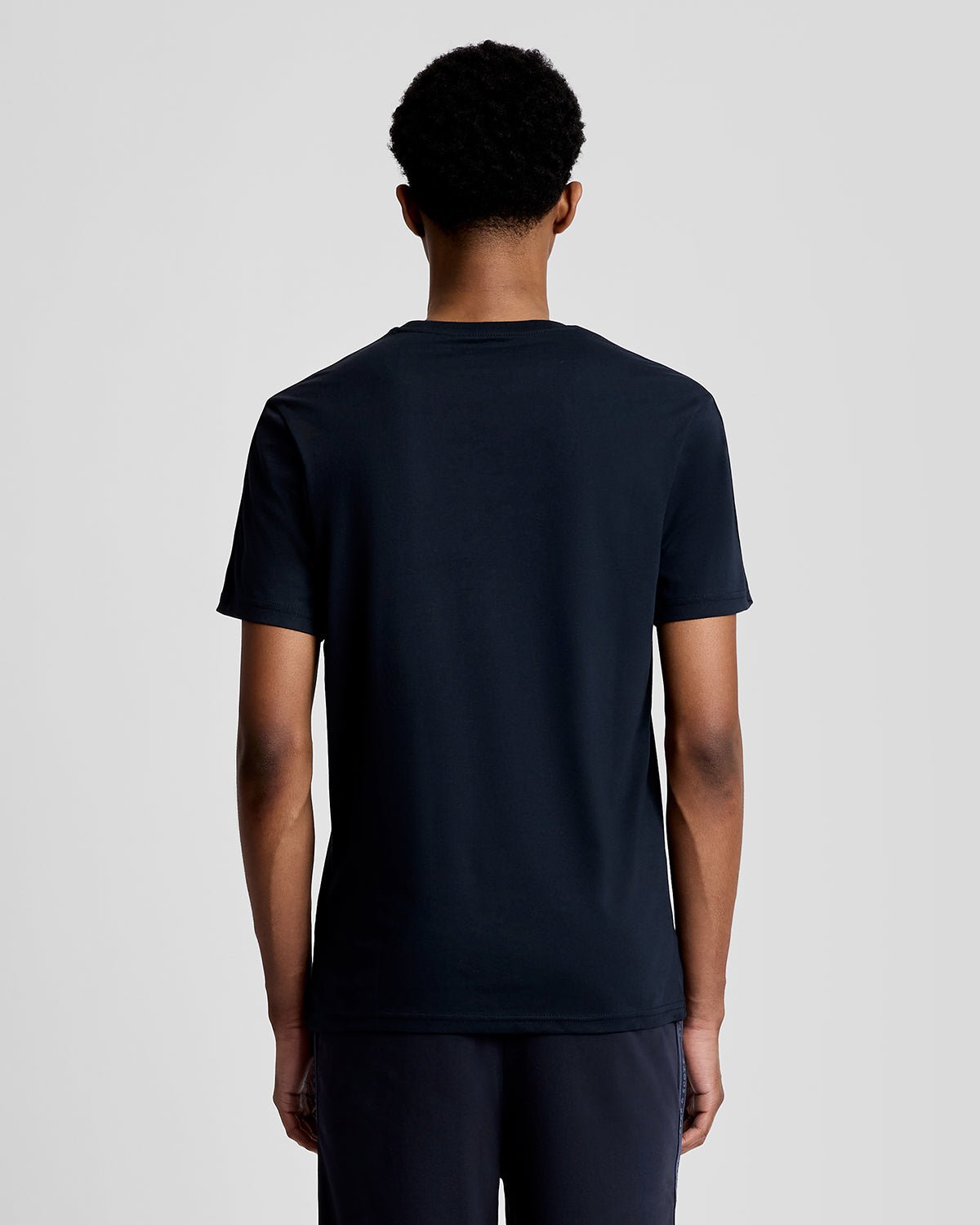 Hombre lleva camiseta deportiva con cinta jacquard en azul marino oscuro.