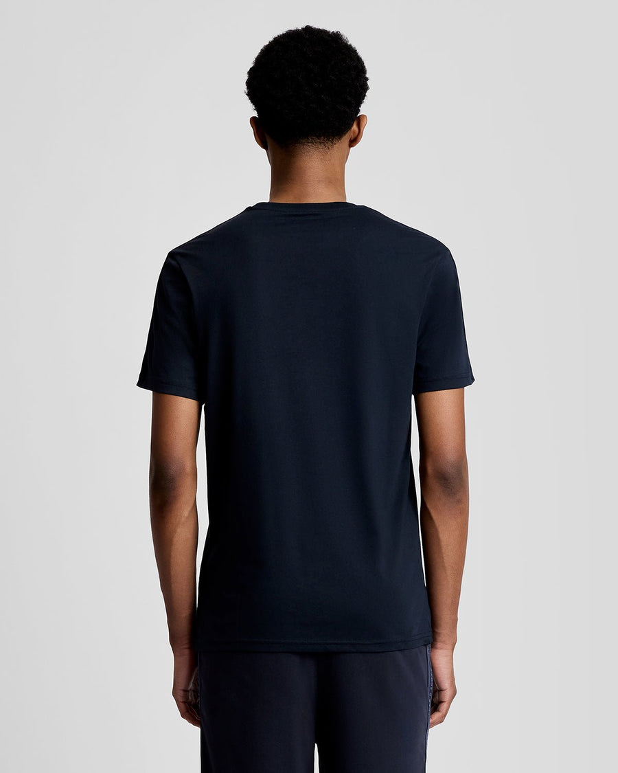 Hombre lleva camiseta deportiva con cinta jacquard en azul marino oscuro.