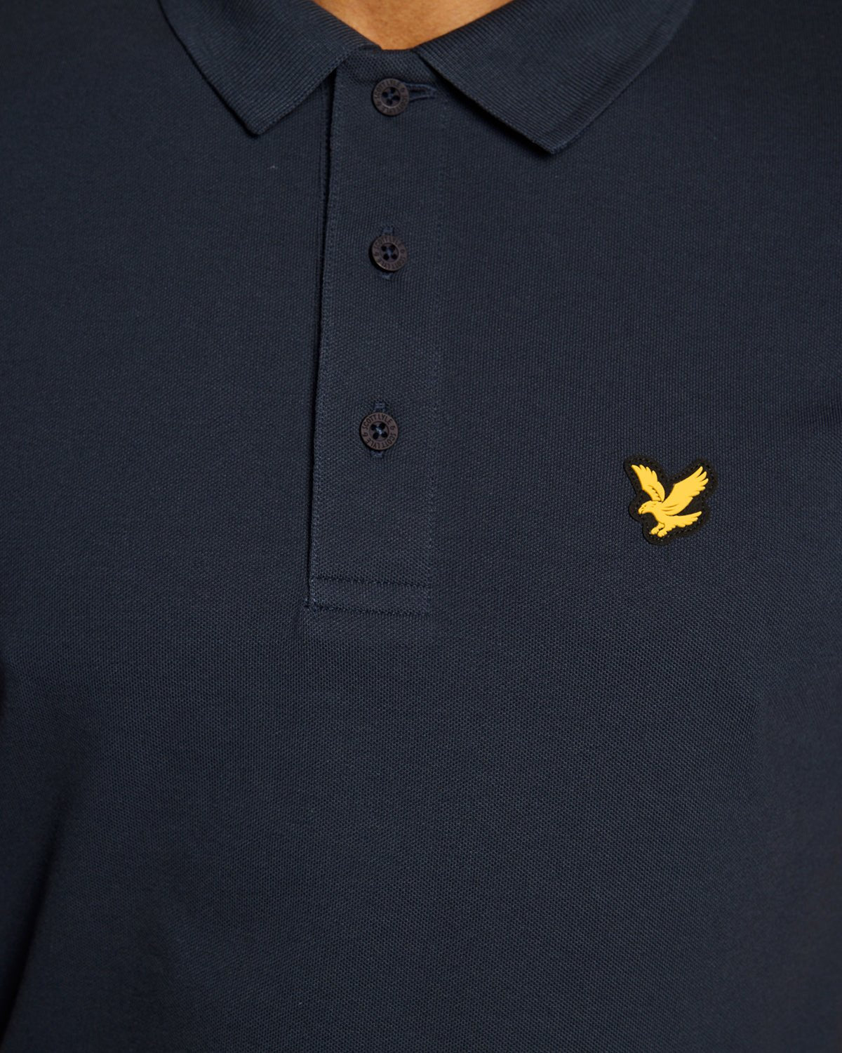 Un homme porte un polo technique bleu marine foncé