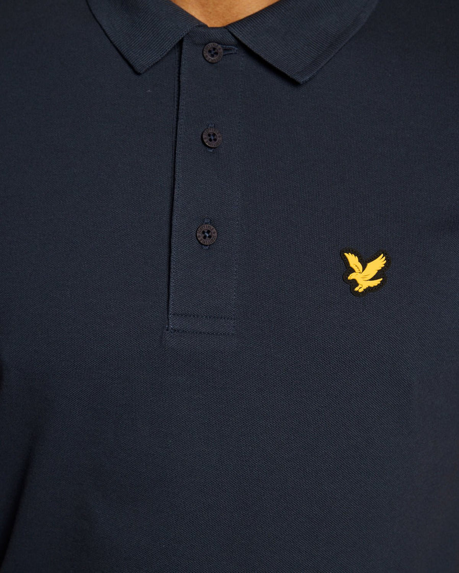 Un homme porte un polo technique bleu marine foncé
