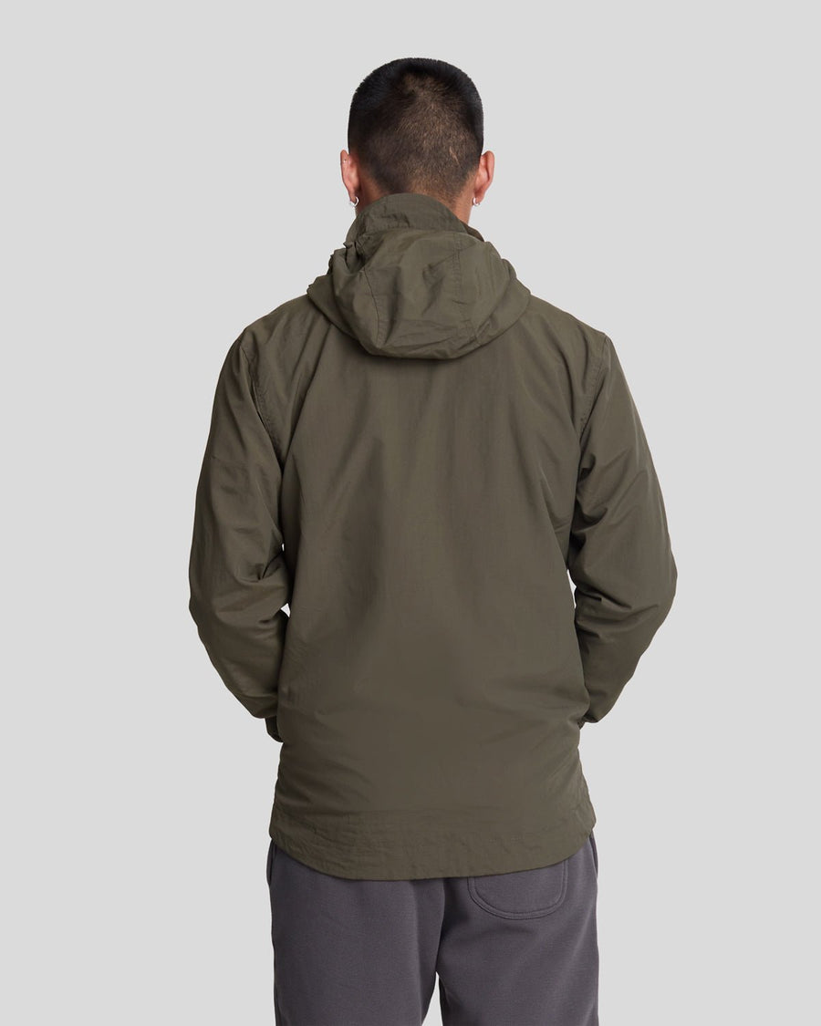 Un homme porte une veste à capuche imperméable de couleur olive