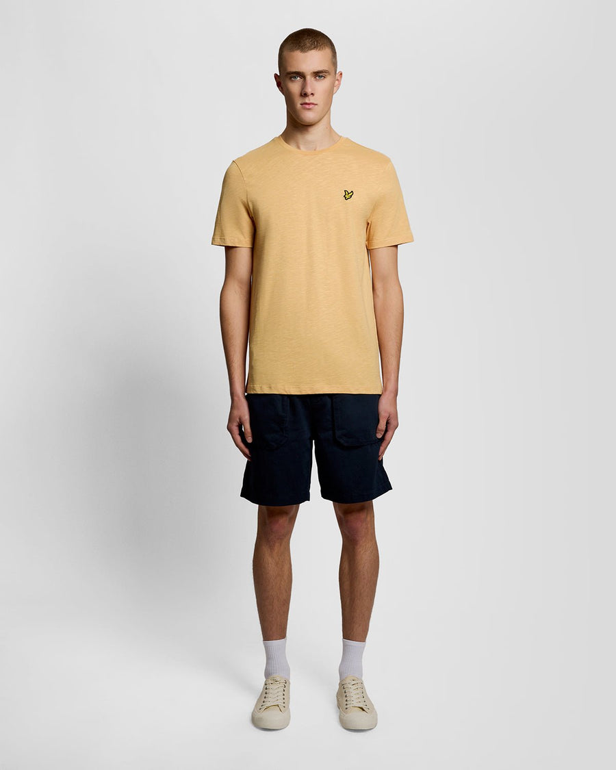 Un homme porte un t-shirt en coton fin texturé, motif nid d'abeille