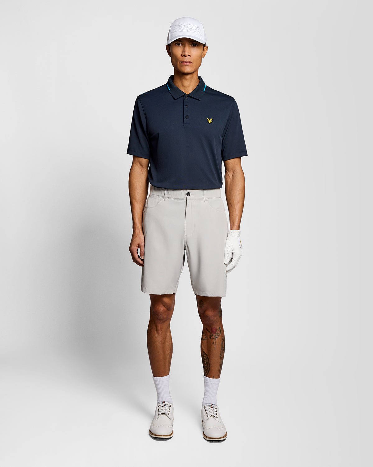 Un homme porte un polo technique à bordures contrastées bleu marine foncé