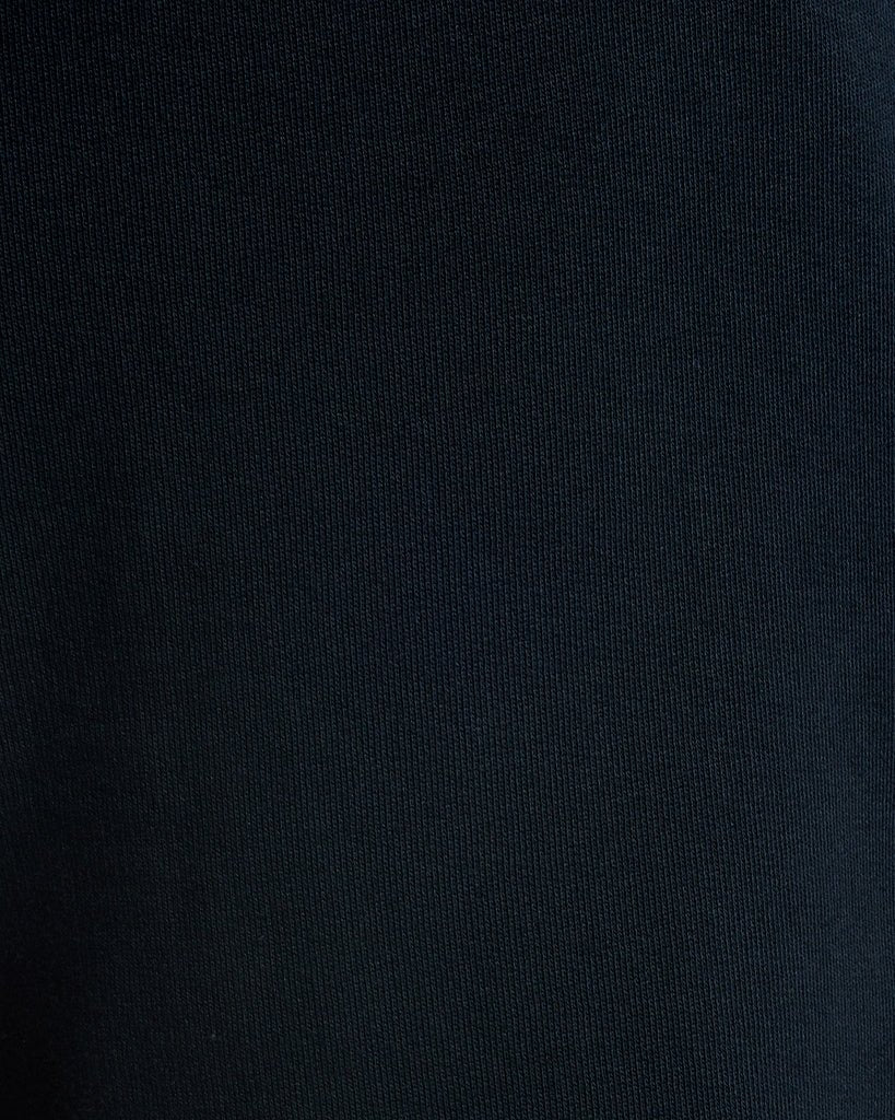 Un homme porte un short de survêtement en coton bleu marine foncé
