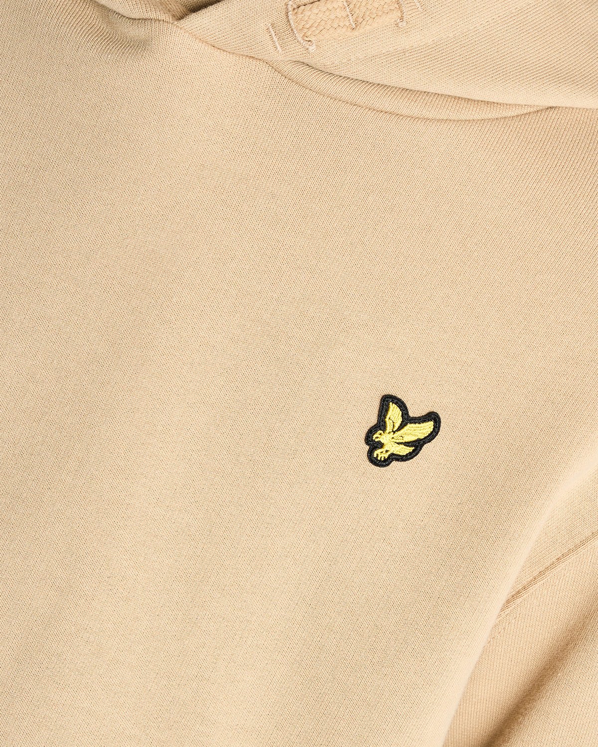 Un homme porte un sweat à capuche en coton Loopback couleur sable foncé