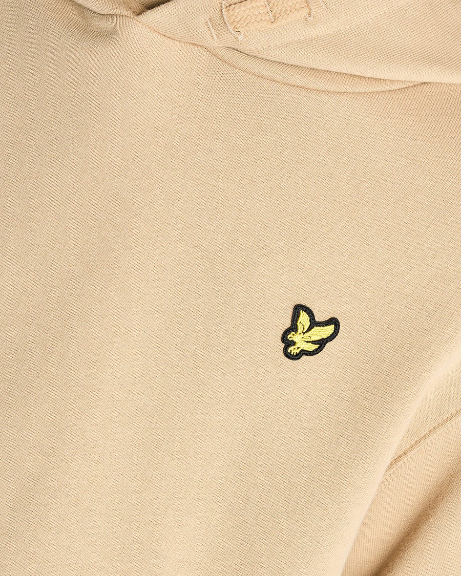 Un homme porte un sweat à capuche en coton Loopback couleur sable foncé