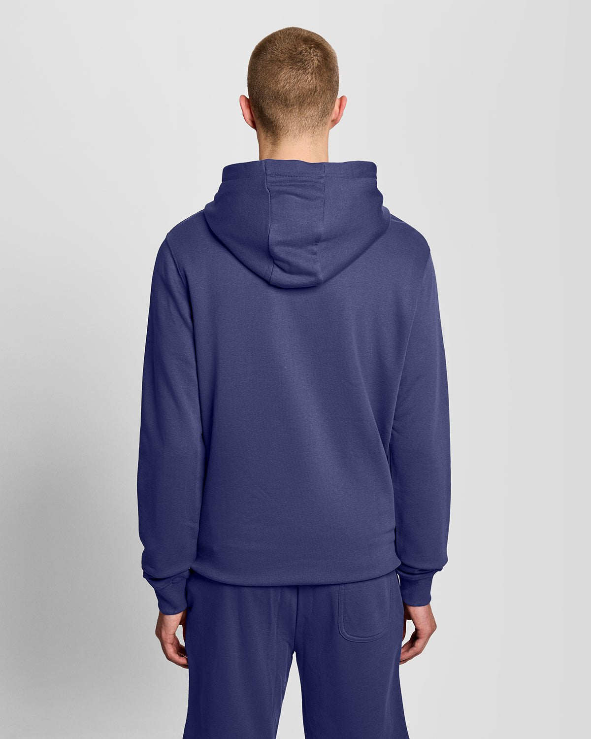 Man draagt een Loopback katoenen hoodie in diep marineblauw