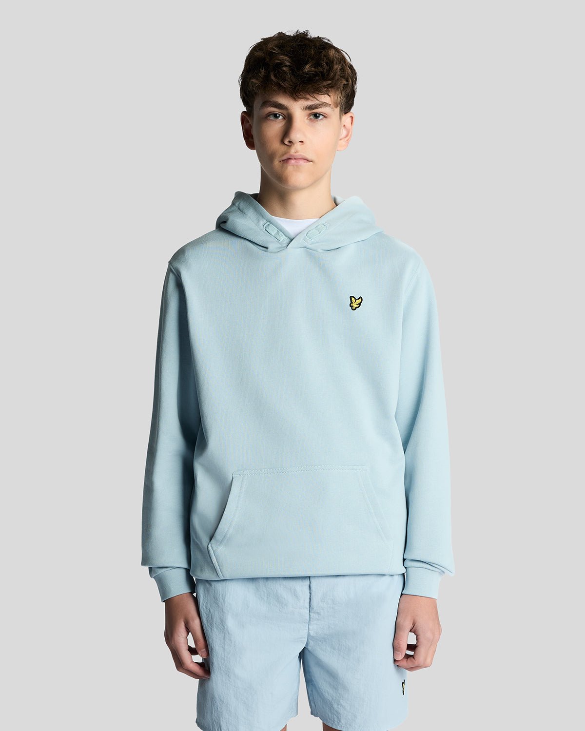 Un homme porte un sweat à capuche en coton Loopback bleu opale