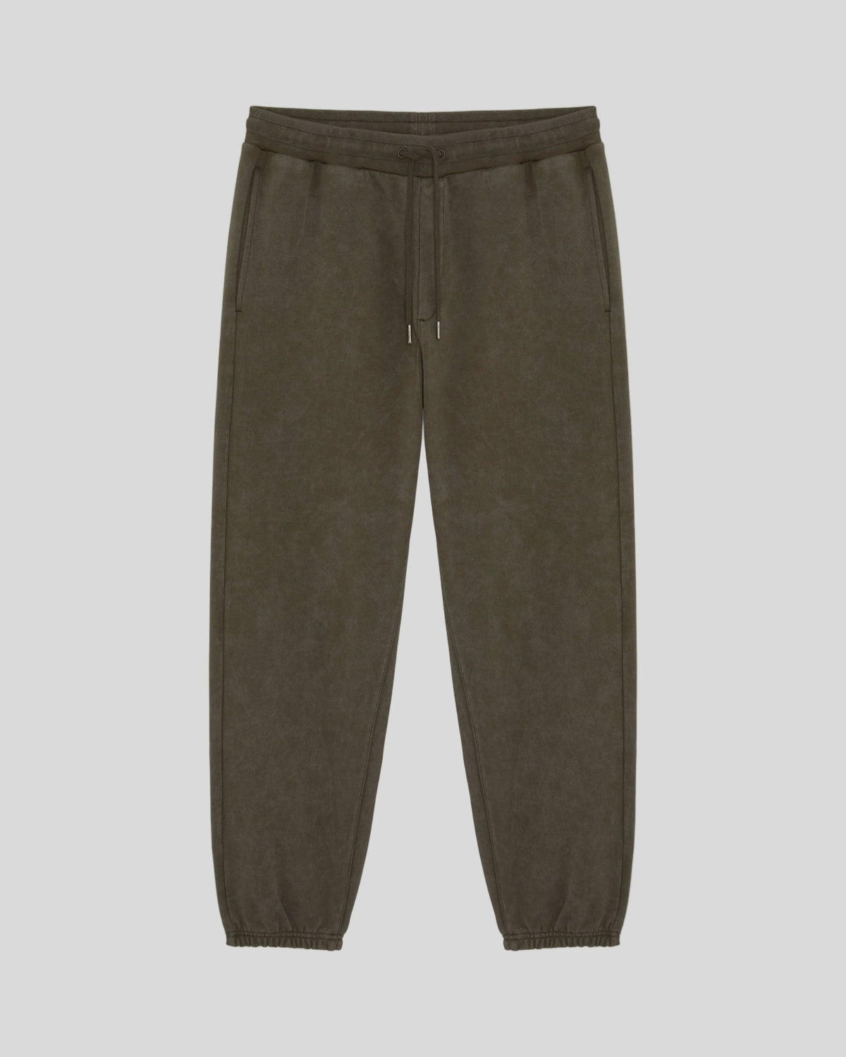 Un homme porte un pantalon de jogging en coton délavé foncé, couleur noir mat