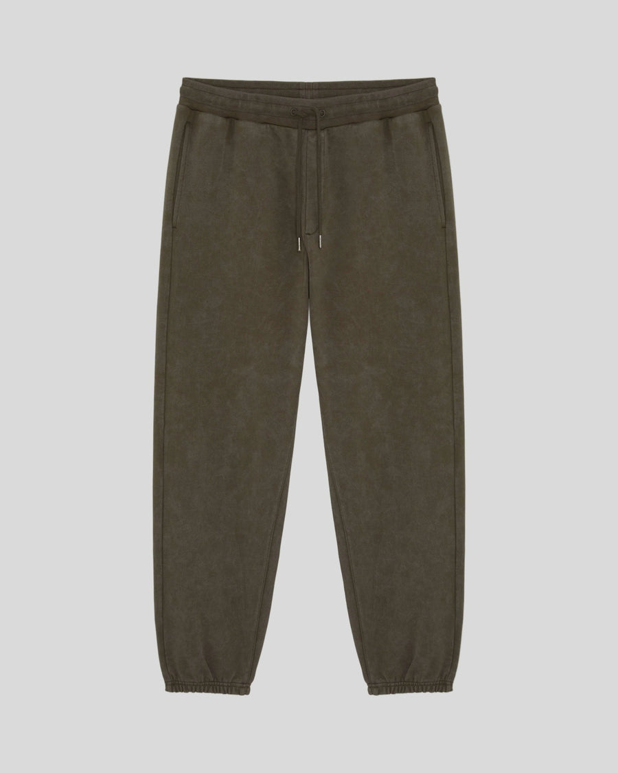 Un homme porte un pantalon de jogging en coton délavé foncé, couleur noir mat