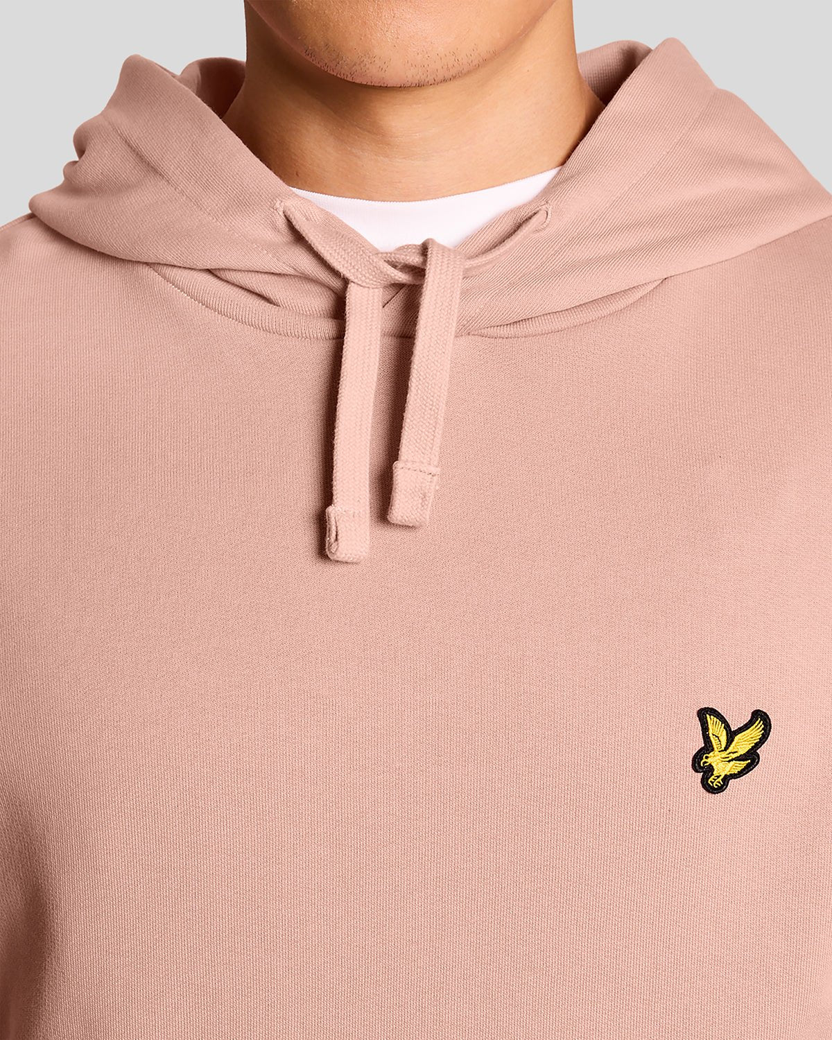L'uomo indossa una felpa con cappuccio Loopback in cotone color rosa pompelmo