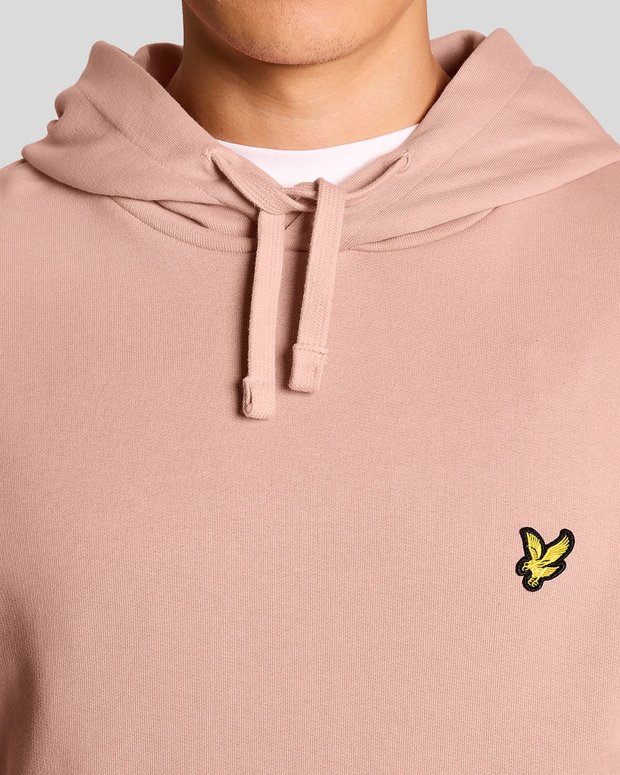 L'uomo indossa una felpa con cappuccio Loopback in cotone color rosa pompelmo