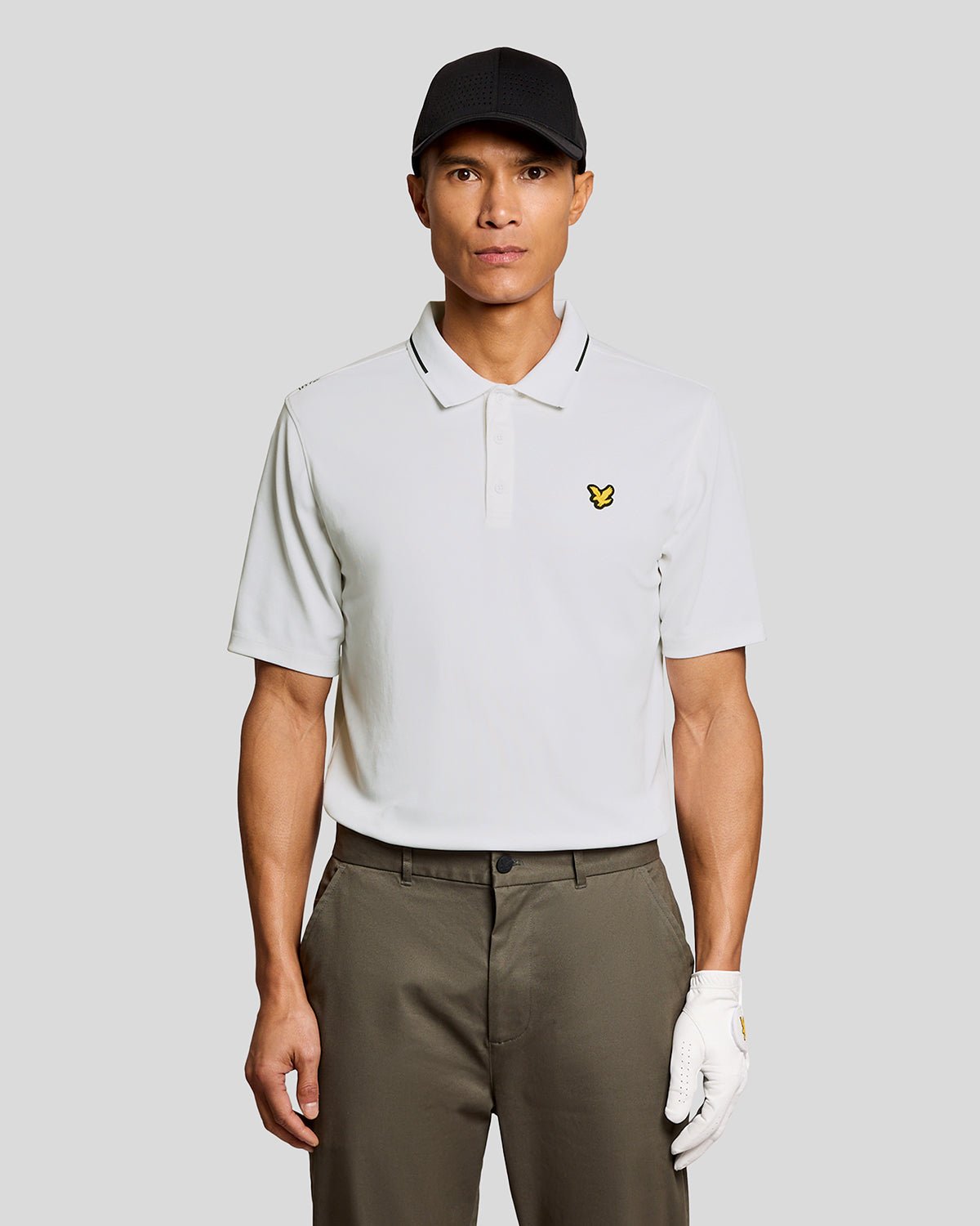 Un homme porte un polo technique à bordures contrastées, de couleur blanche