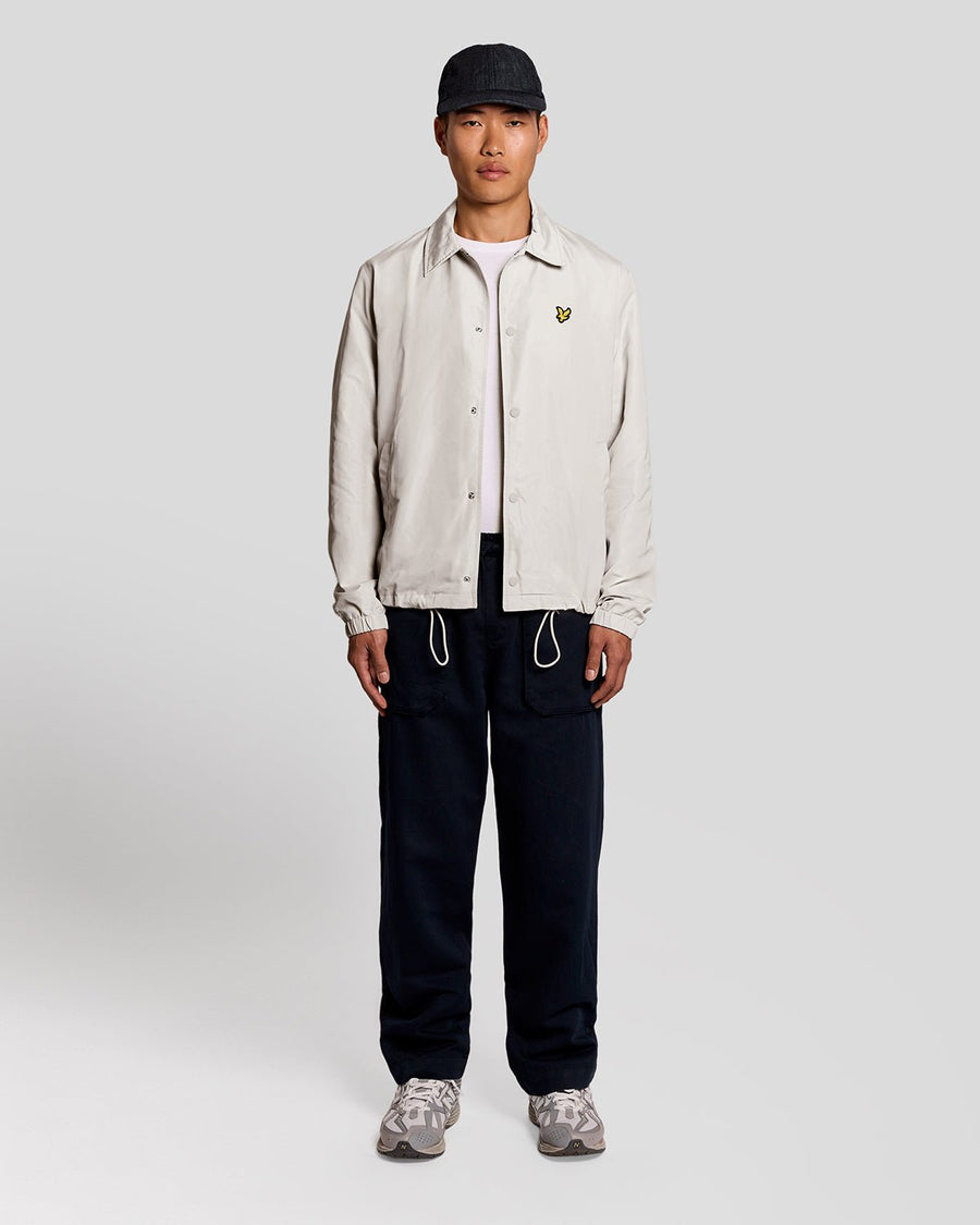Un homme porte une veste Coach légère de couleur Cove