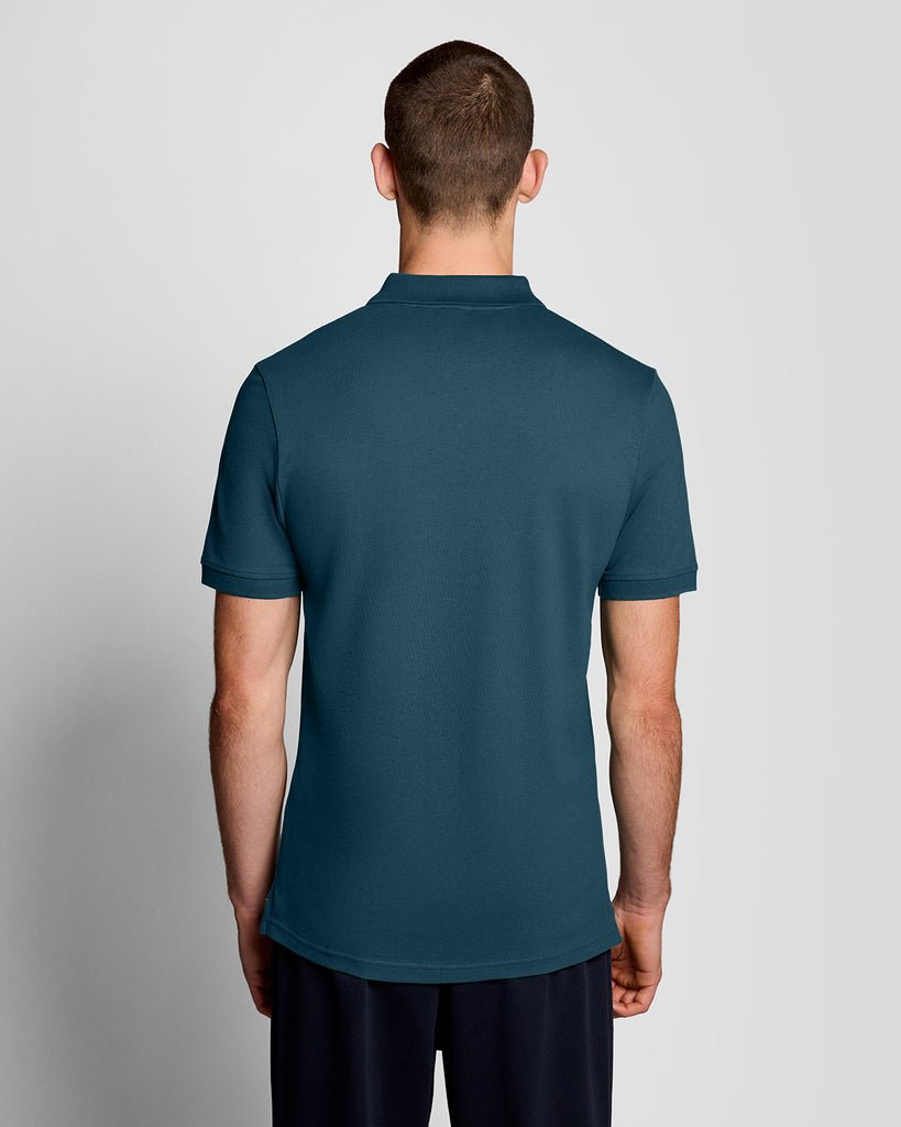Un homme porte un polo « Everyday Cotton » de couleur bleu sarcelle intense