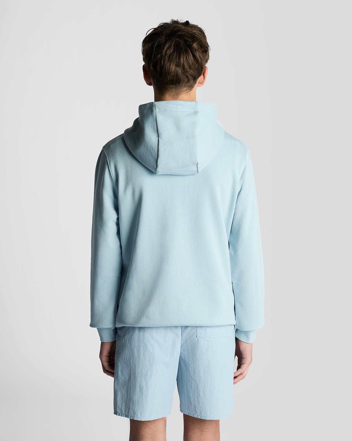 Un homme porte un sweat à capuche en coton Loopback bleu opale