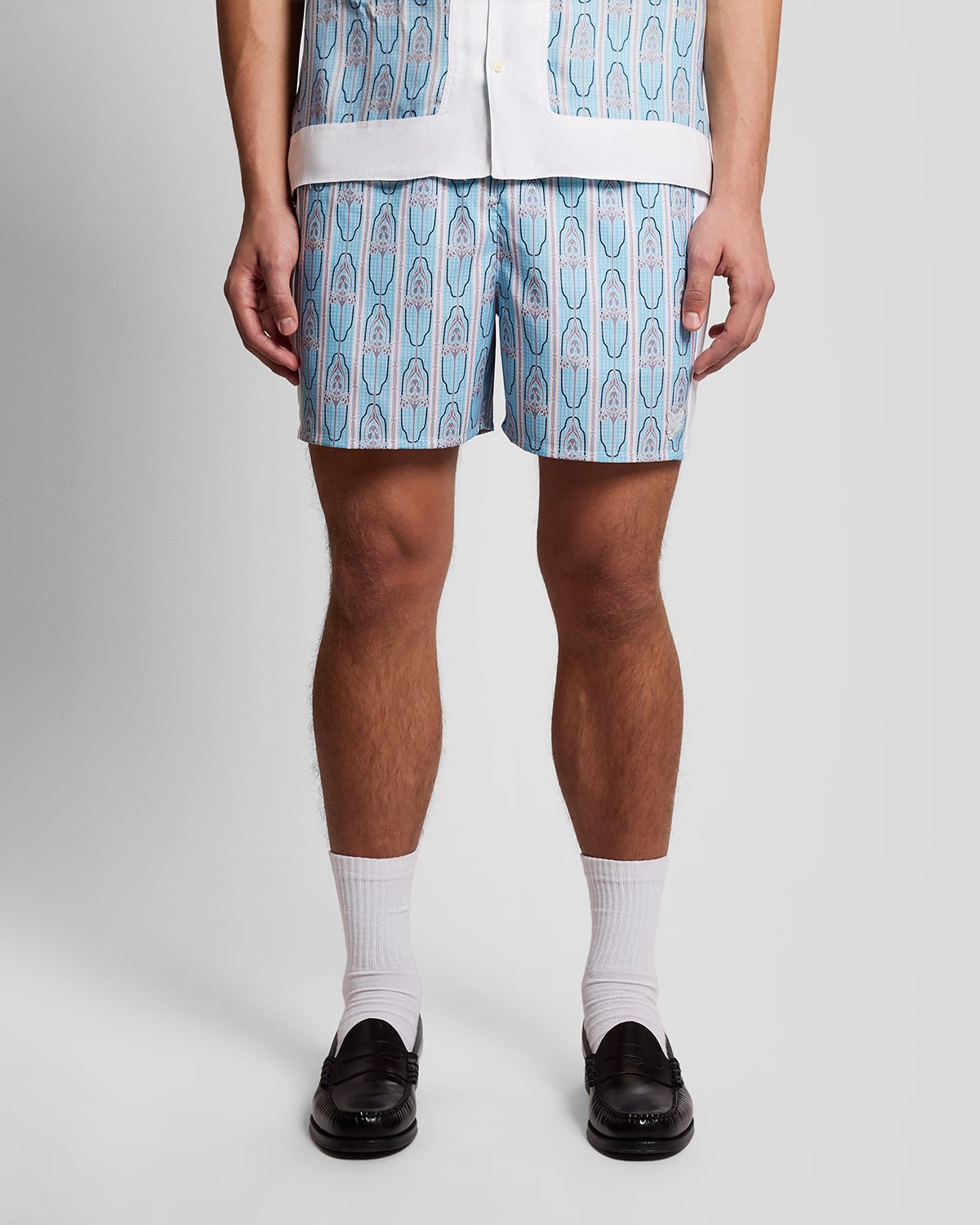 Homme portant un short de bain à motifs floraux, couleur crème amande/bleu de Parme
