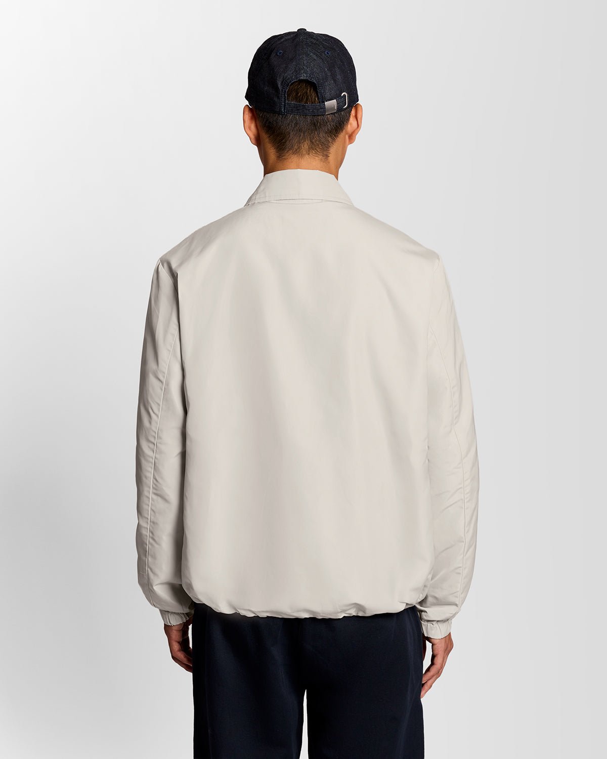 Un homme porte une veste Coach légère de couleur Cove