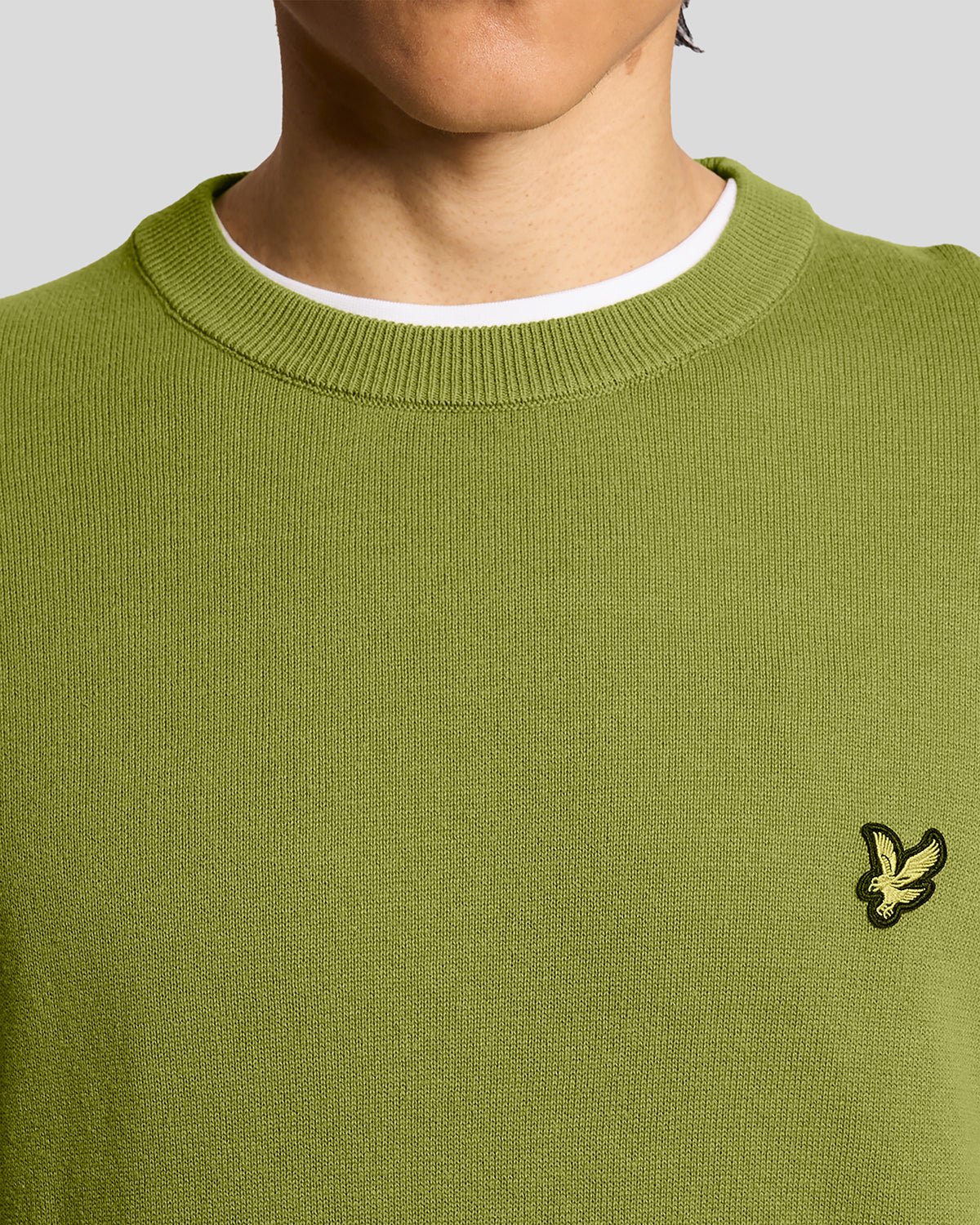 Homme portant un pull à col rond en coton vert buisson