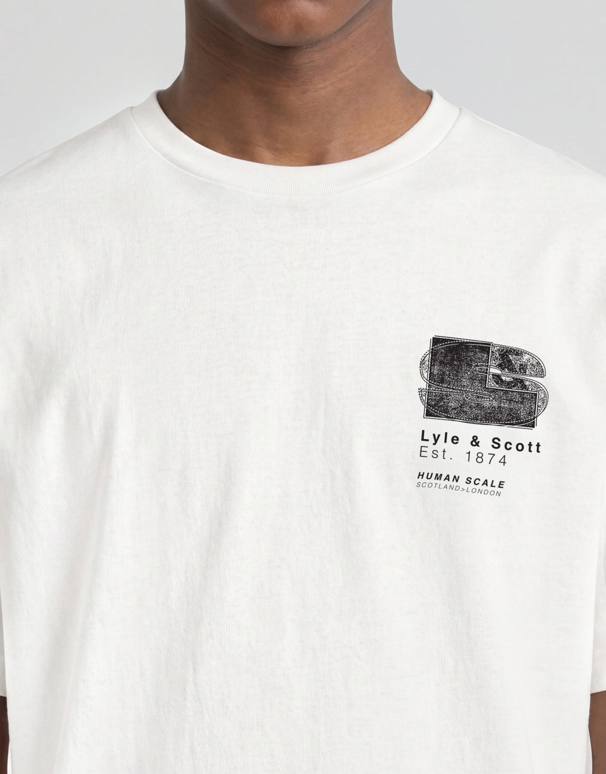Pojke bär en vit T-shirt med halvtonat monogramtryck