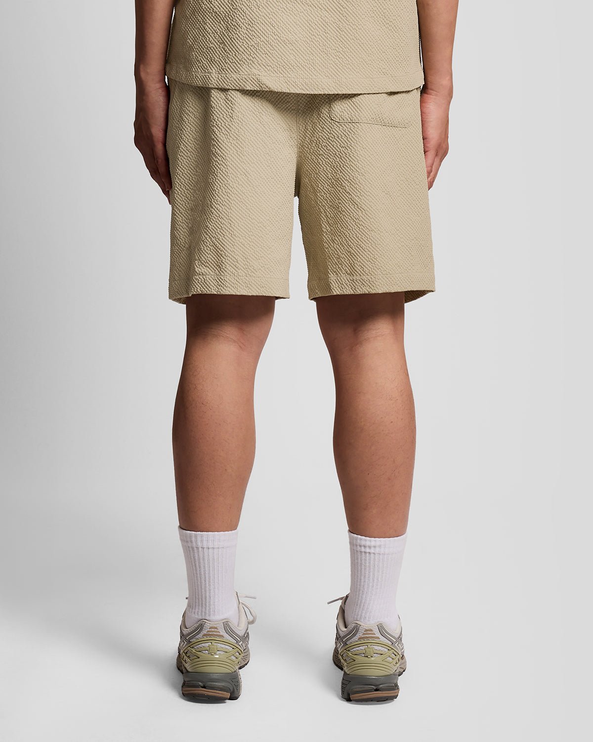 Un homme porte un short de plage texturé couleur Savona Clay