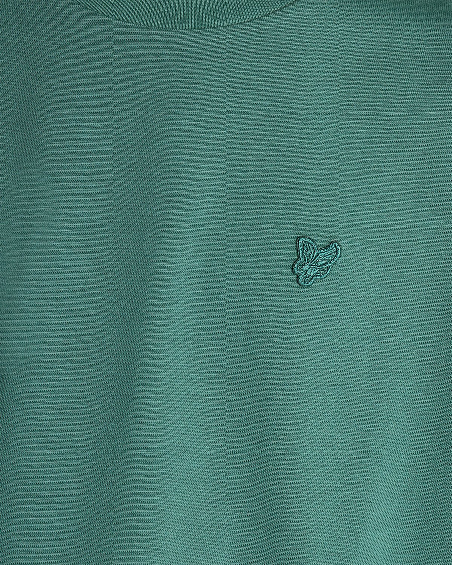 Un homme porte un t-shirt ample épais de couleur Everglade