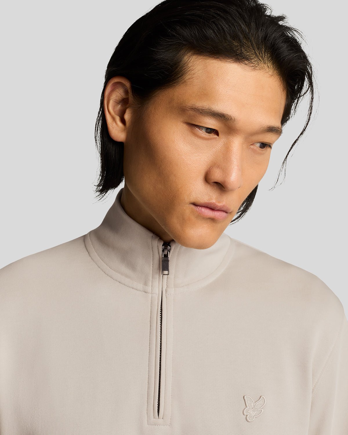 Un homme porte un sweat-shirt à fermeture éclair 1/4 en coton ultra-fin, couleur Cove