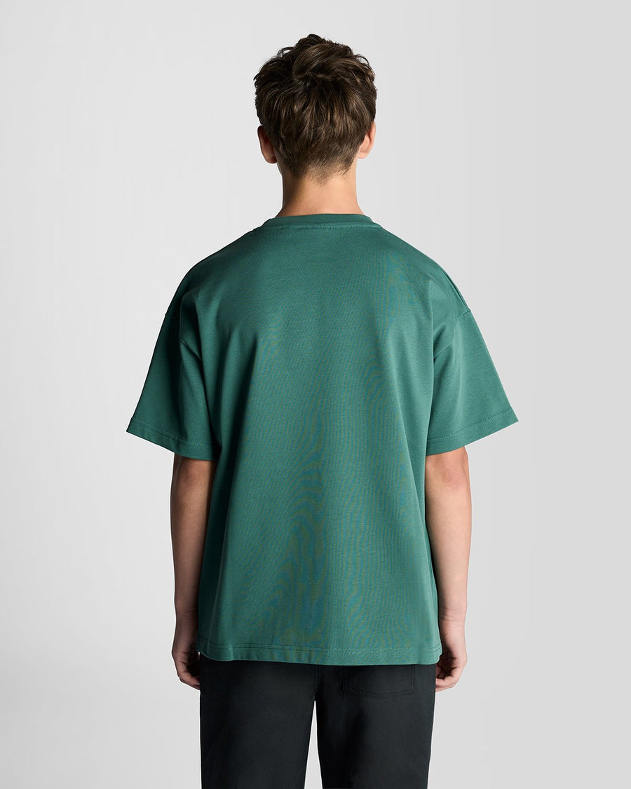 Un homme porte un t-shirt ample épais de couleur Everglade