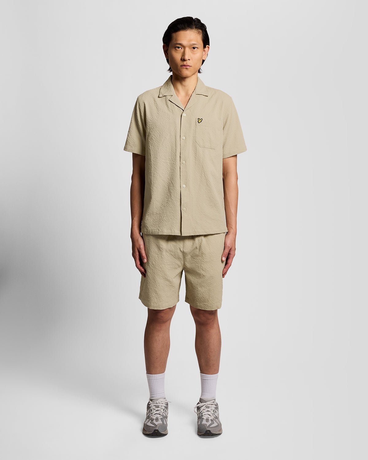 Un homme porte un short de plage texturé couleur Savona Clay