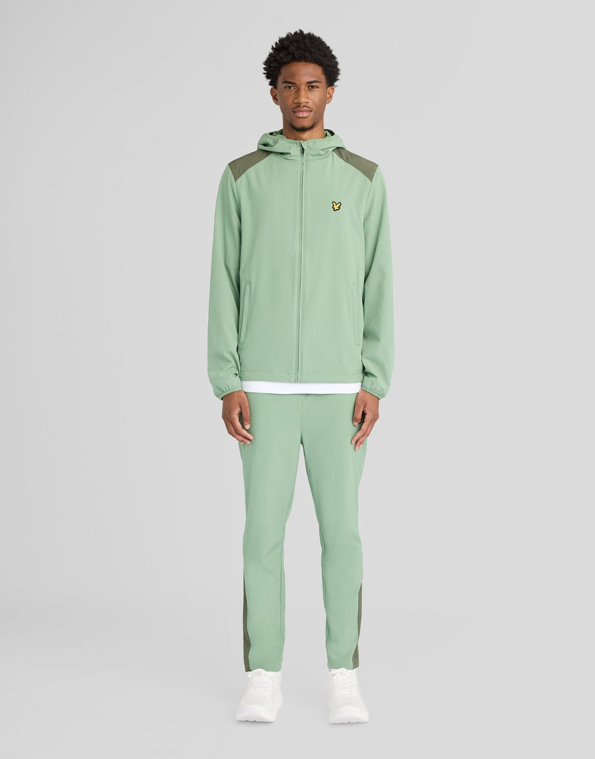 Man bär träningsbyxor med paneler i färgerna Botanical Green/Cactus Green