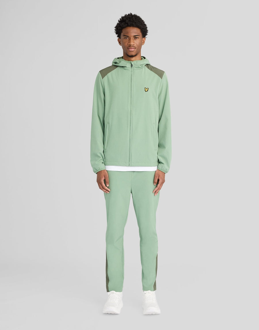 Man bär träningsbyxor med paneler i färgerna Botanical Green/Cactus Green