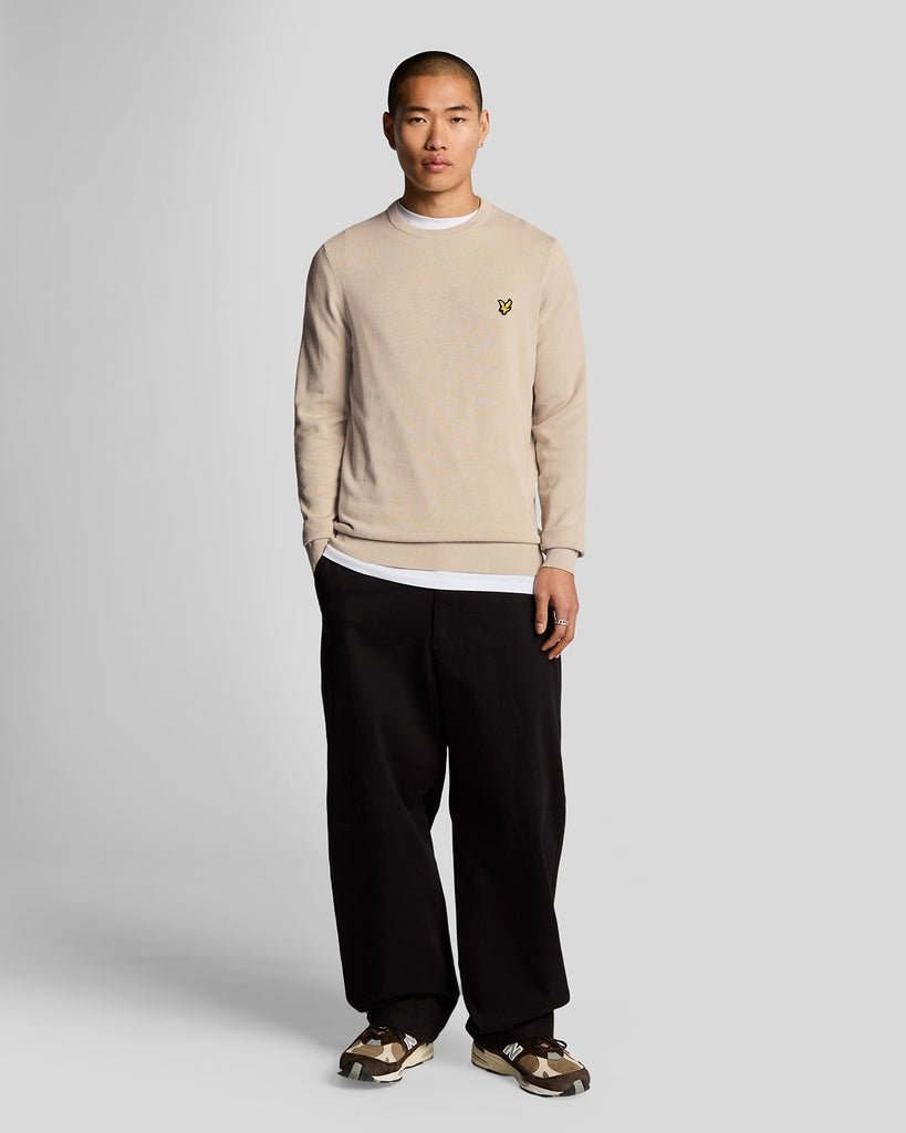 Un homme porte un pull à col rond en coton, couleur Cove