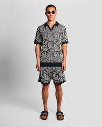 Man wears Emblem Ribbed Knitted Shorts in Dark Navy/ Cove