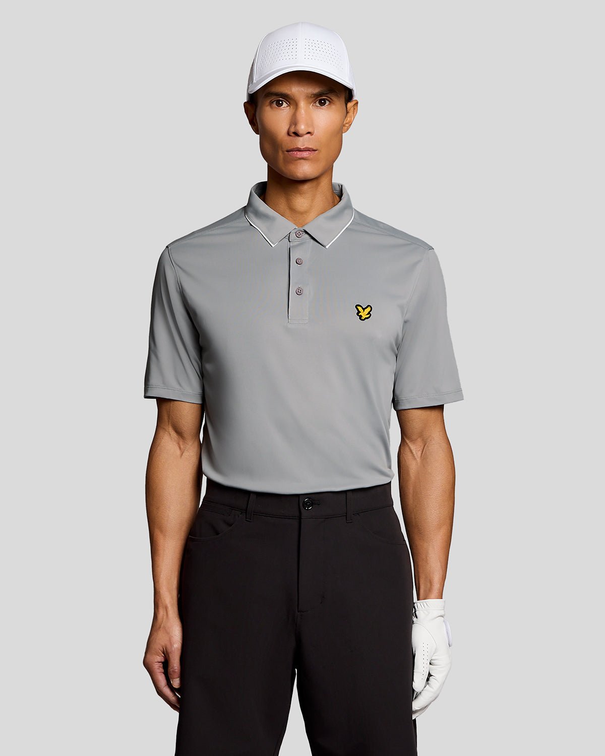 Un homme porte un polo à col contrasté de couleur « Ultimate Grey »