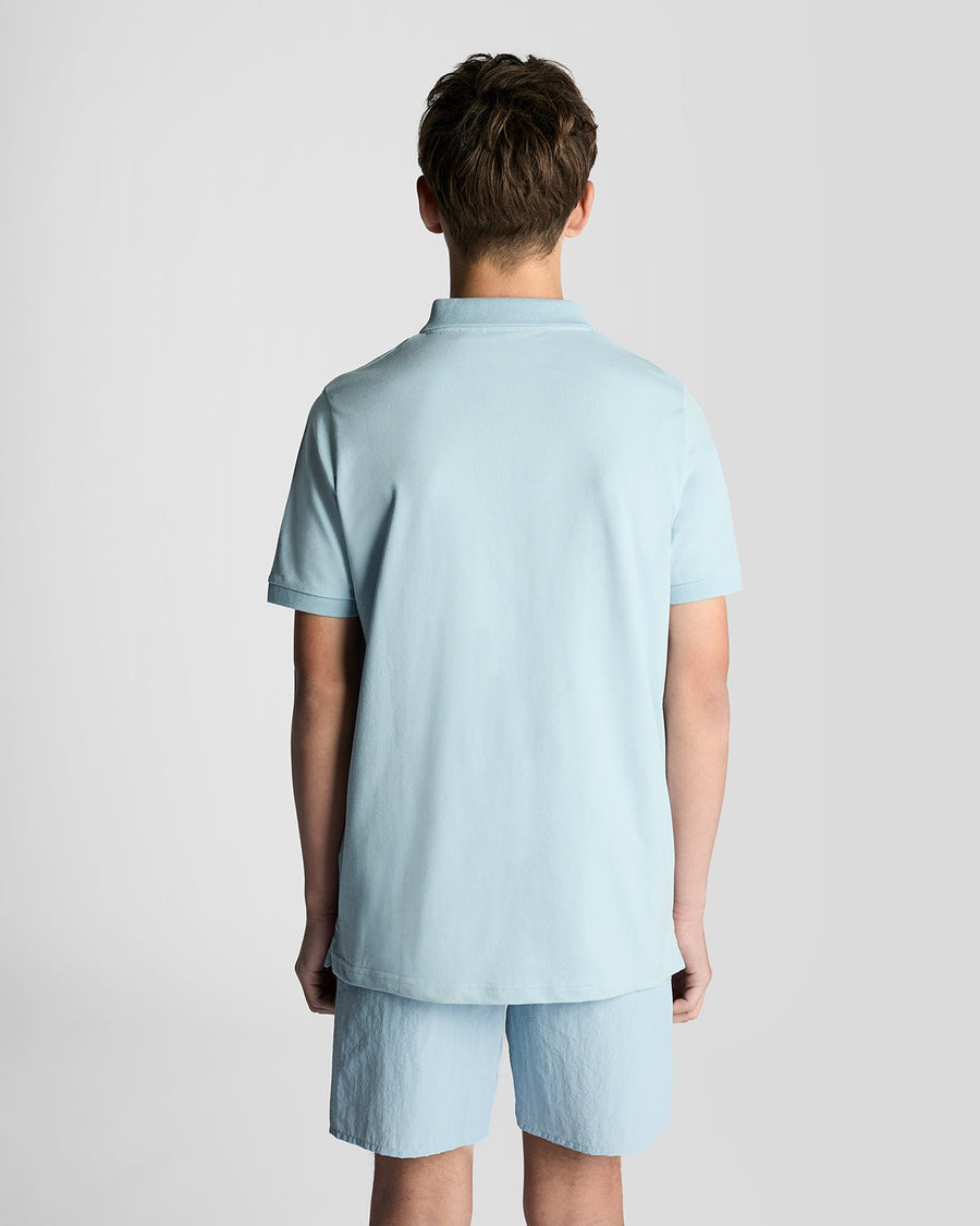 Un homme porte un polo en coton bleu opale