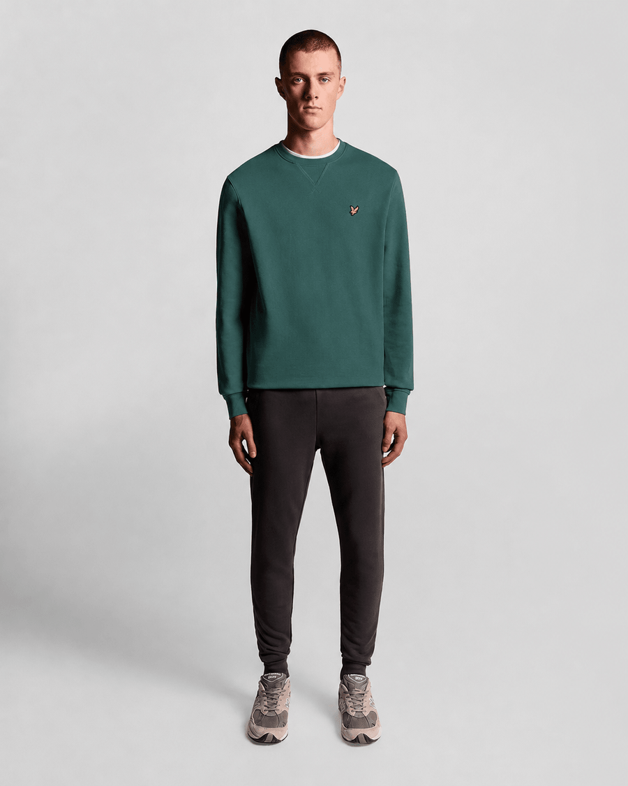 Un homme porte un sweat-shirt à col rond en coton, couleur Everglade
