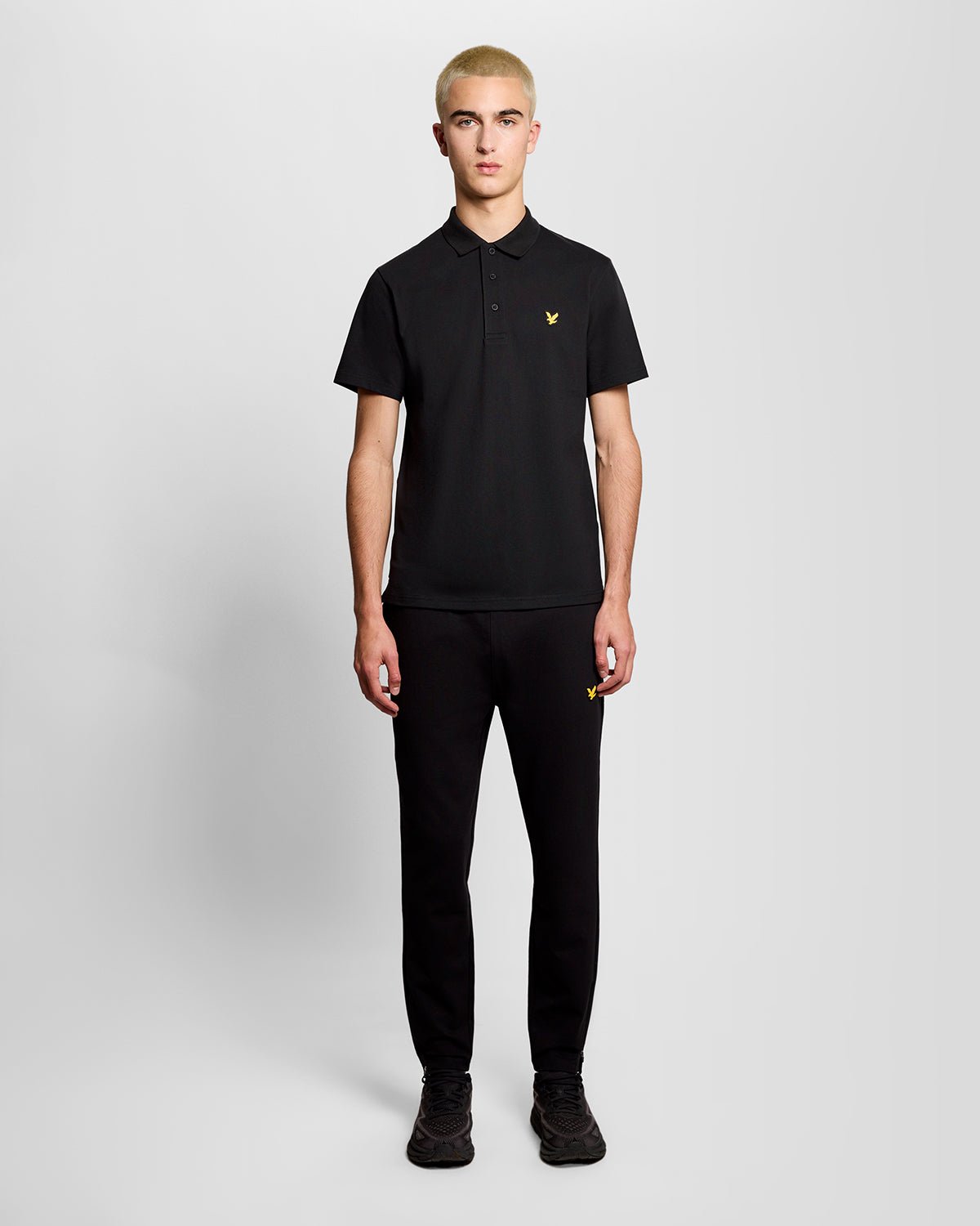 Un homme porte un polo de sport noir de jais