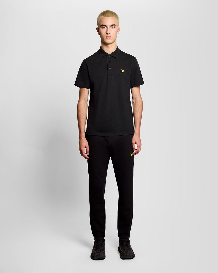 Un homme porte un polo de sport noir de jais