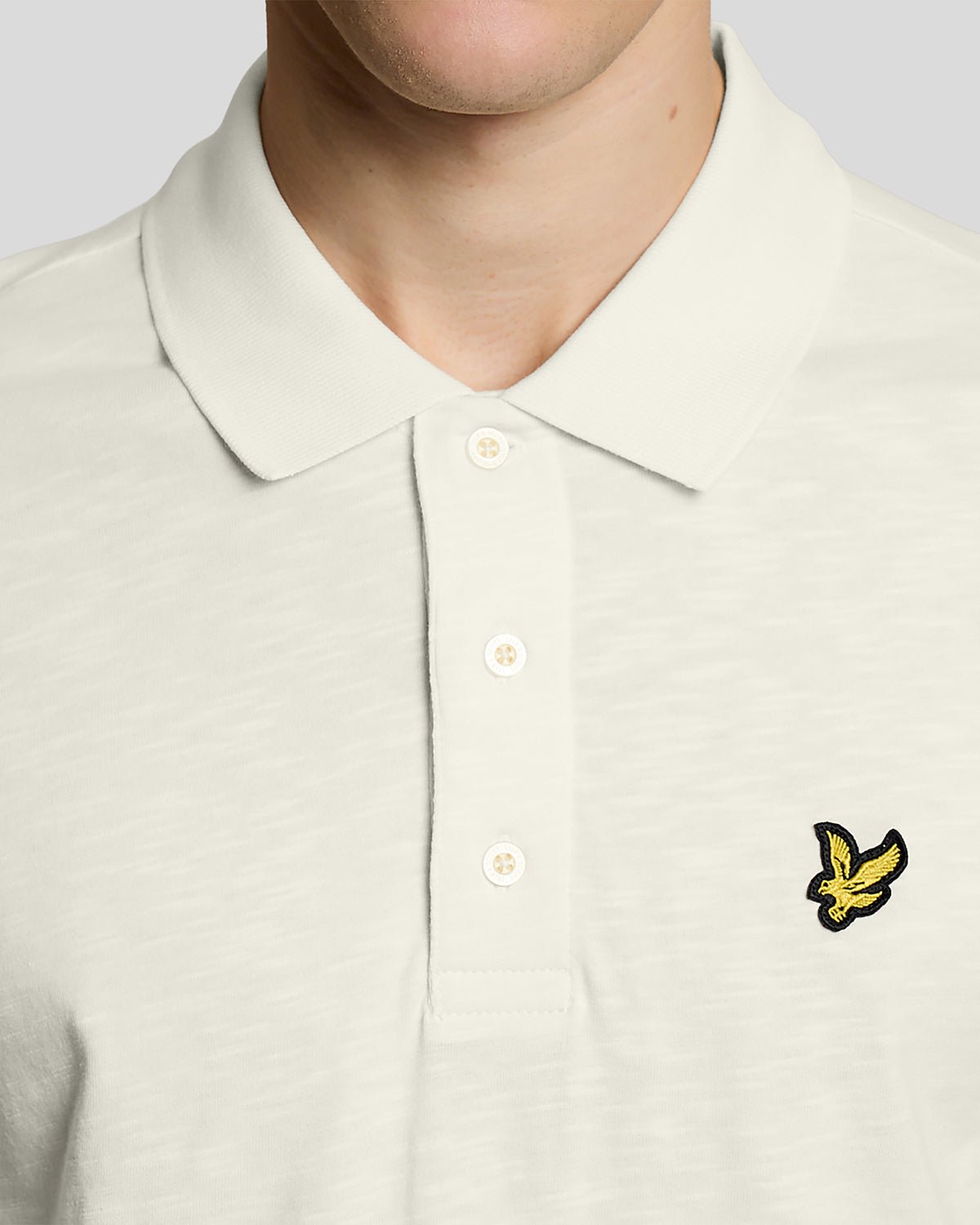Un homme porte un polo en coton fin texturé, couleur « Ice Cream »