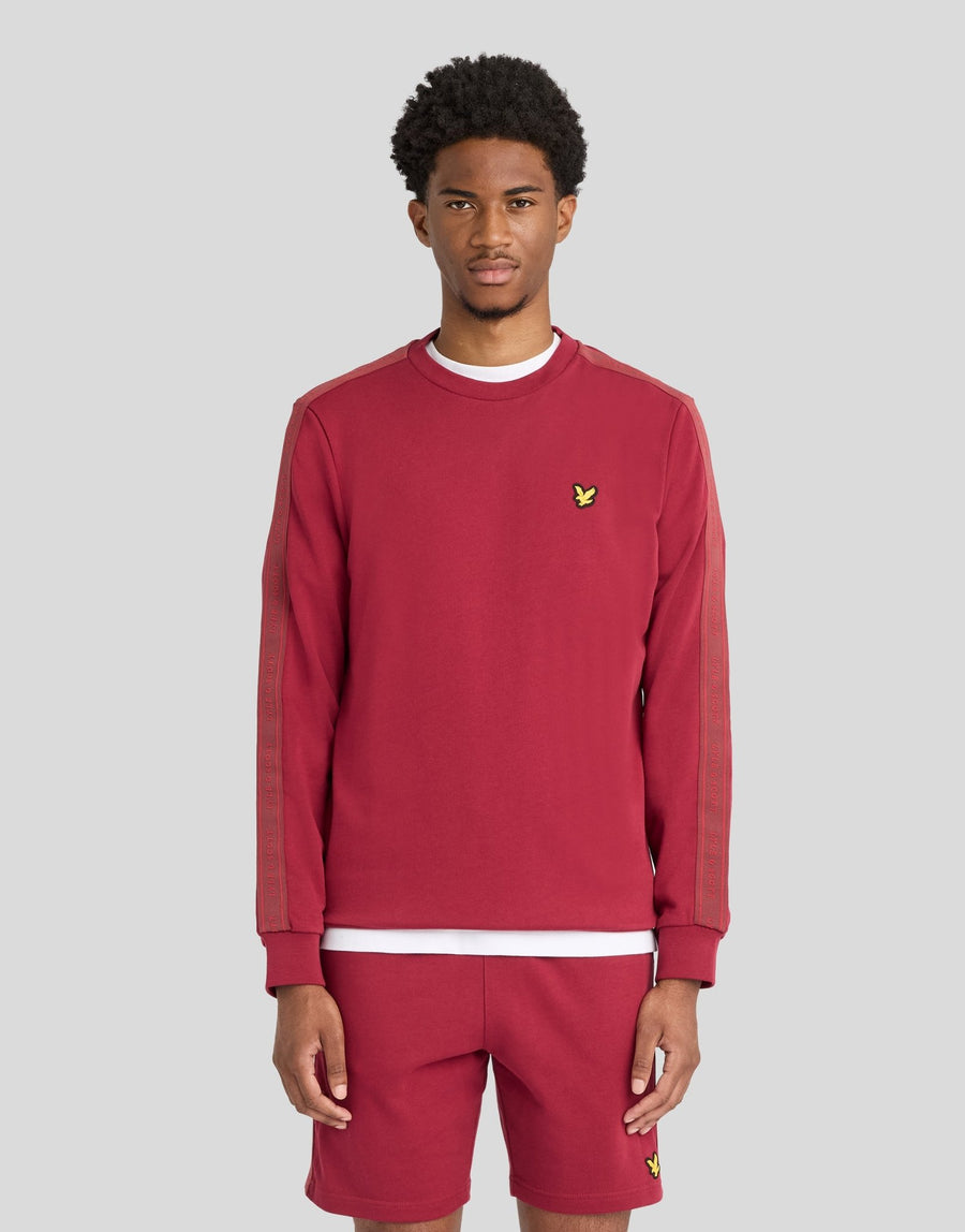 Man wears Sports Tape Crew Neck Sweatshirt in Plum
