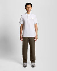 Man wears Washed Cotton Trousers in Soft Black