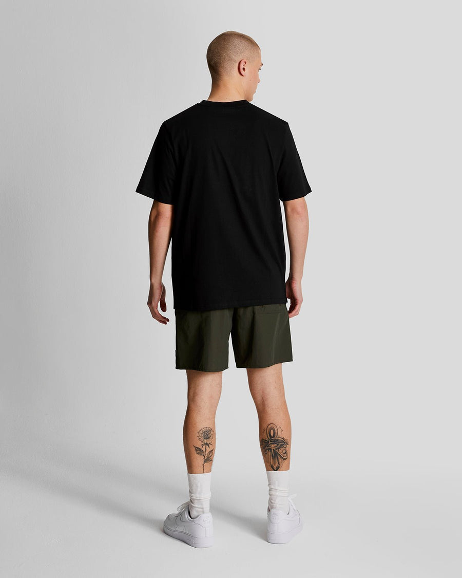 Man wears Plain Swim Shorts in Olive