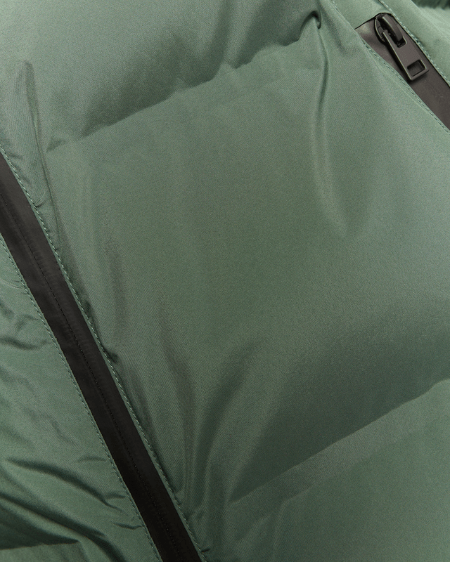 Homme portant un gilet matelassé à capuche épais, couleur Dark Pine