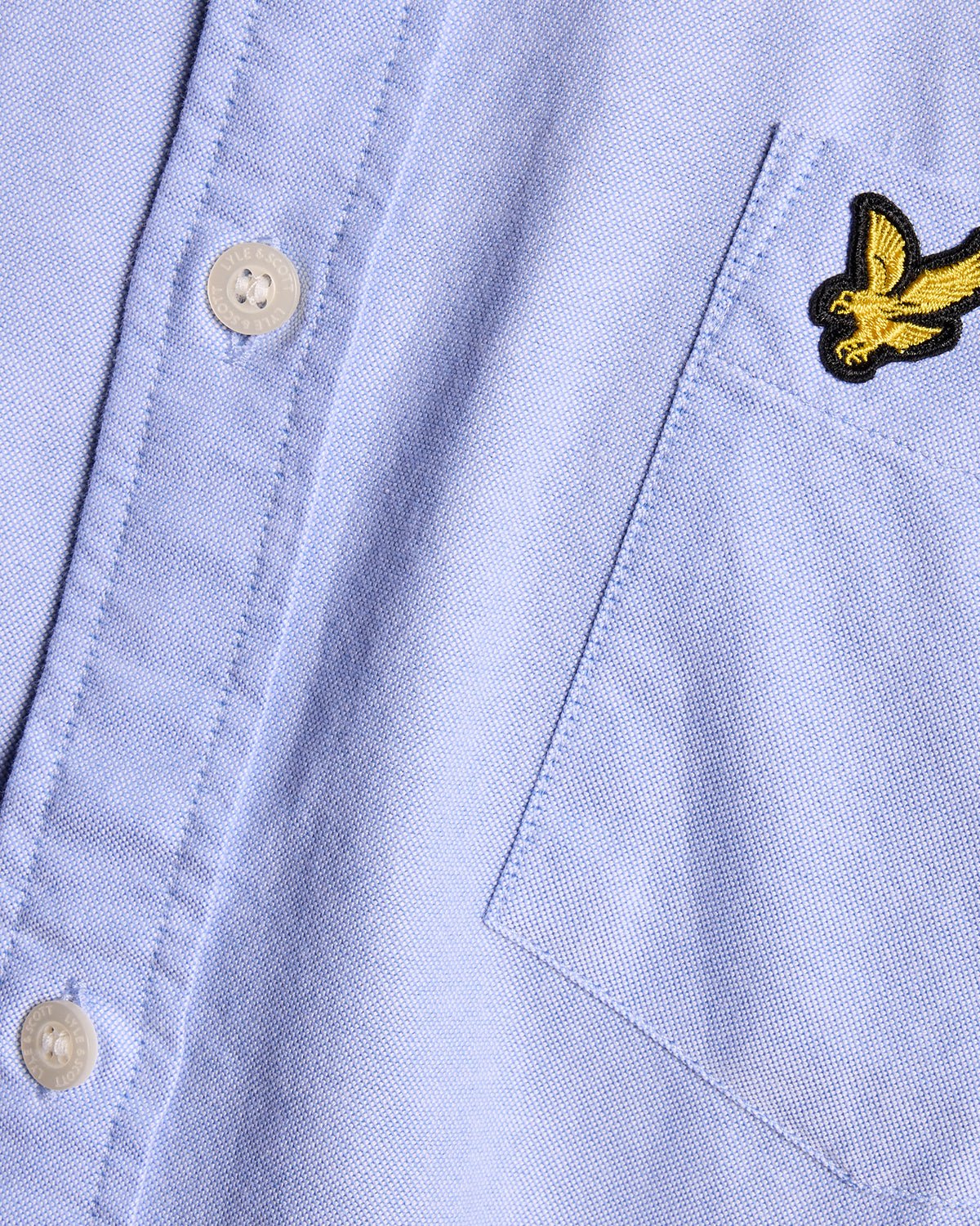 Man wears Cotton Button Down Oxford Shirt in Riviera