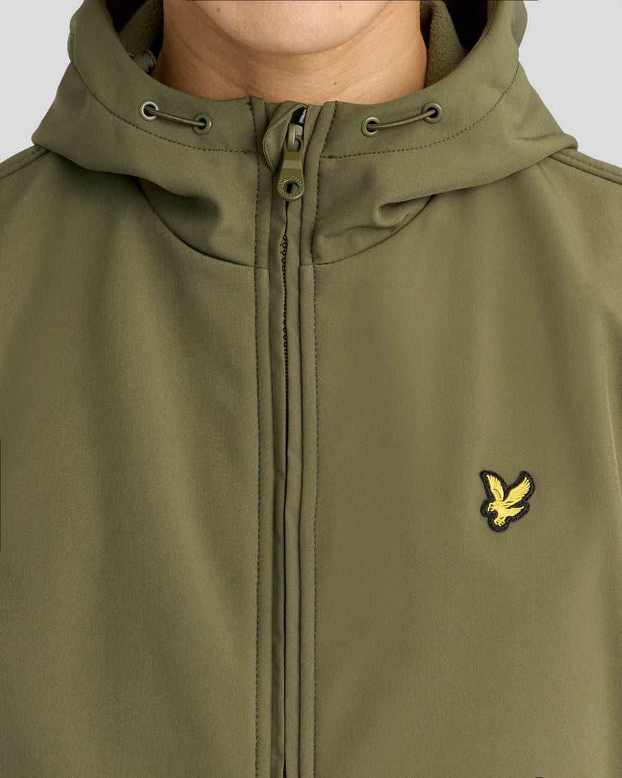 Mann trägt eine mit Fleece gefütterte Softshell-Jacke in der Farbe „True Olive“